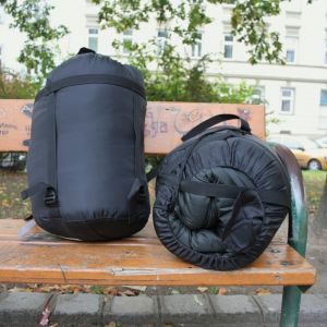 Zwei schwarze Schlafsäcke auf einer Parkbank