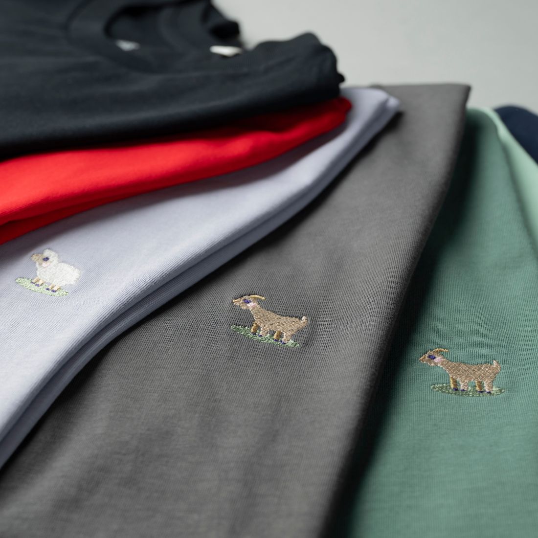 Schwarzes T-Shirt. mit Ziegen Stickerei von einem Modell getragen