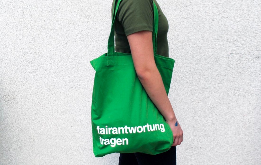 Frau trägt einen grünen Jutebeutel mit dem Aufdruck "Fairantwortung tragen"
