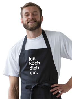 Mann trägt eine Kochschürze mit Aufdruck "ich koch dich ein"